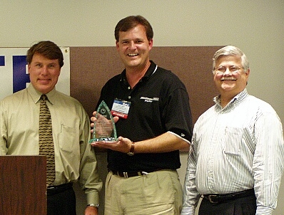 In the middle, Russ Finney, CIO, Tokyo Electron America, Inc. is honored for Executive Leadership by Awards Chairman Scott Calvin and Neogent's Steve Bankhead